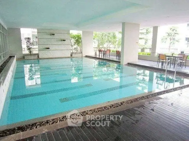 Luxurious indoor swimming pool with modern design and seating area, perfect for relaxation and leisure.