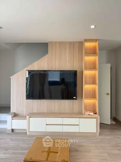 Modern living room with wall-mounted TV and stylish shelving unit