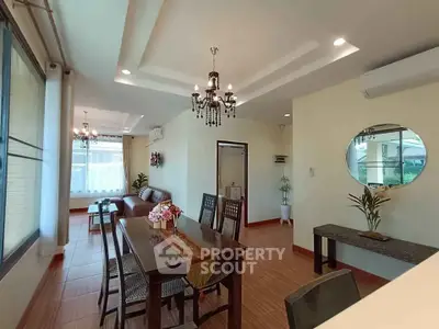 Elegant open-plan living and dining area with chandeliers and large windows