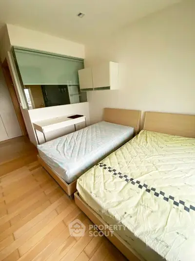 Spacious bedroom with twin beds and modern decor in a stylish apartment.