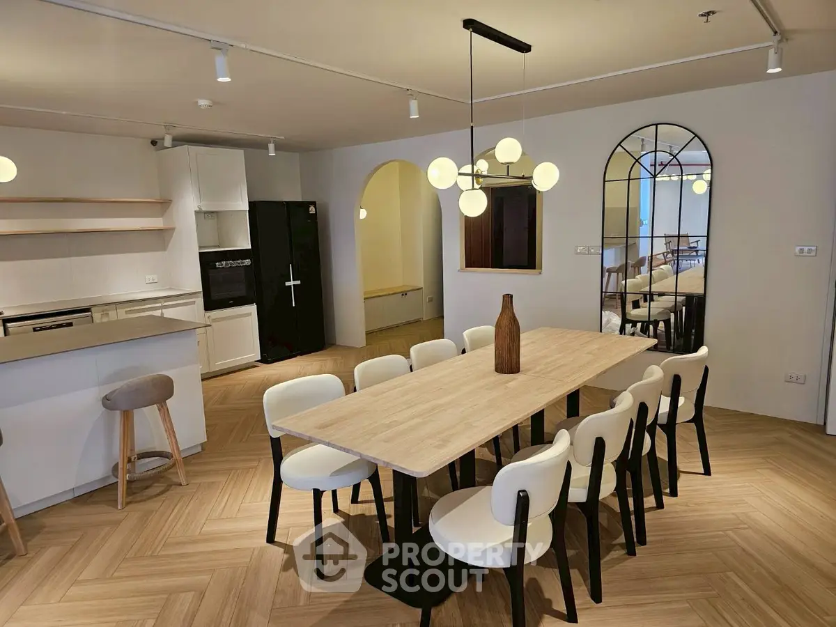 Modern dining area with elegant lighting and stylish wooden table seating eight.
