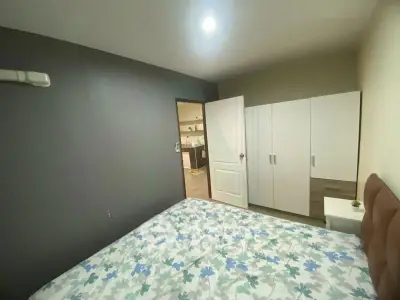 Cozy bedroom with modern decor and spacious wardrobe in a stylish apartment.