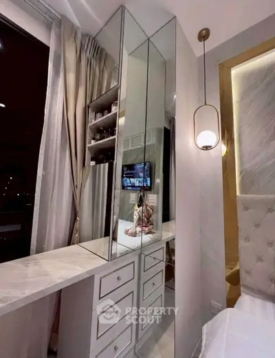 Luxurious bedroom with elegant mirrored vanity and plush headboard, perfect for modern living.