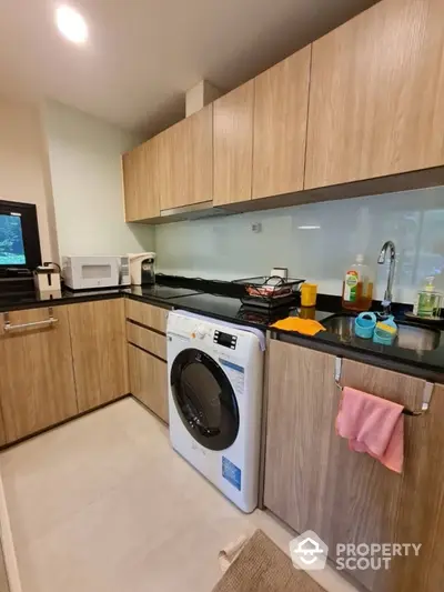 Modern kitchen with wooden cabinets and built-in washing machine