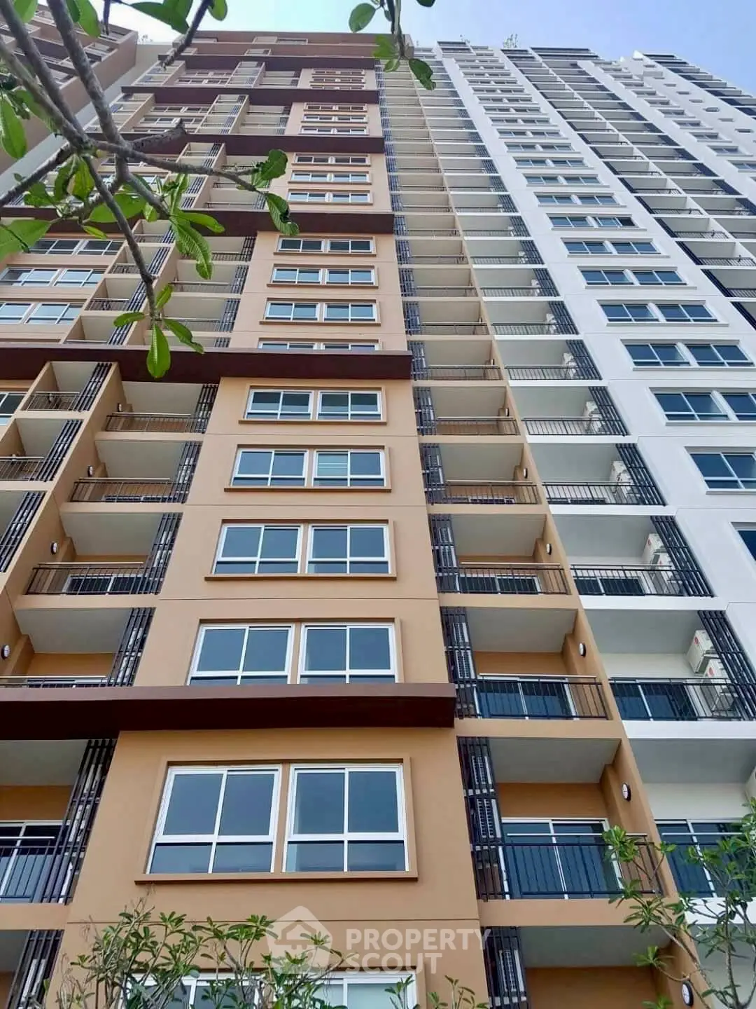 Modern high-rise building exterior with multiple balconies and sleek design.