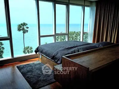 Luxurious bedroom with stunning ocean view and floor-to-ceiling windows.