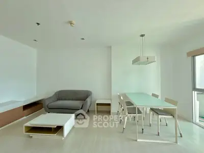 Modern living room with sleek furniture and dining area in a bright apartment
