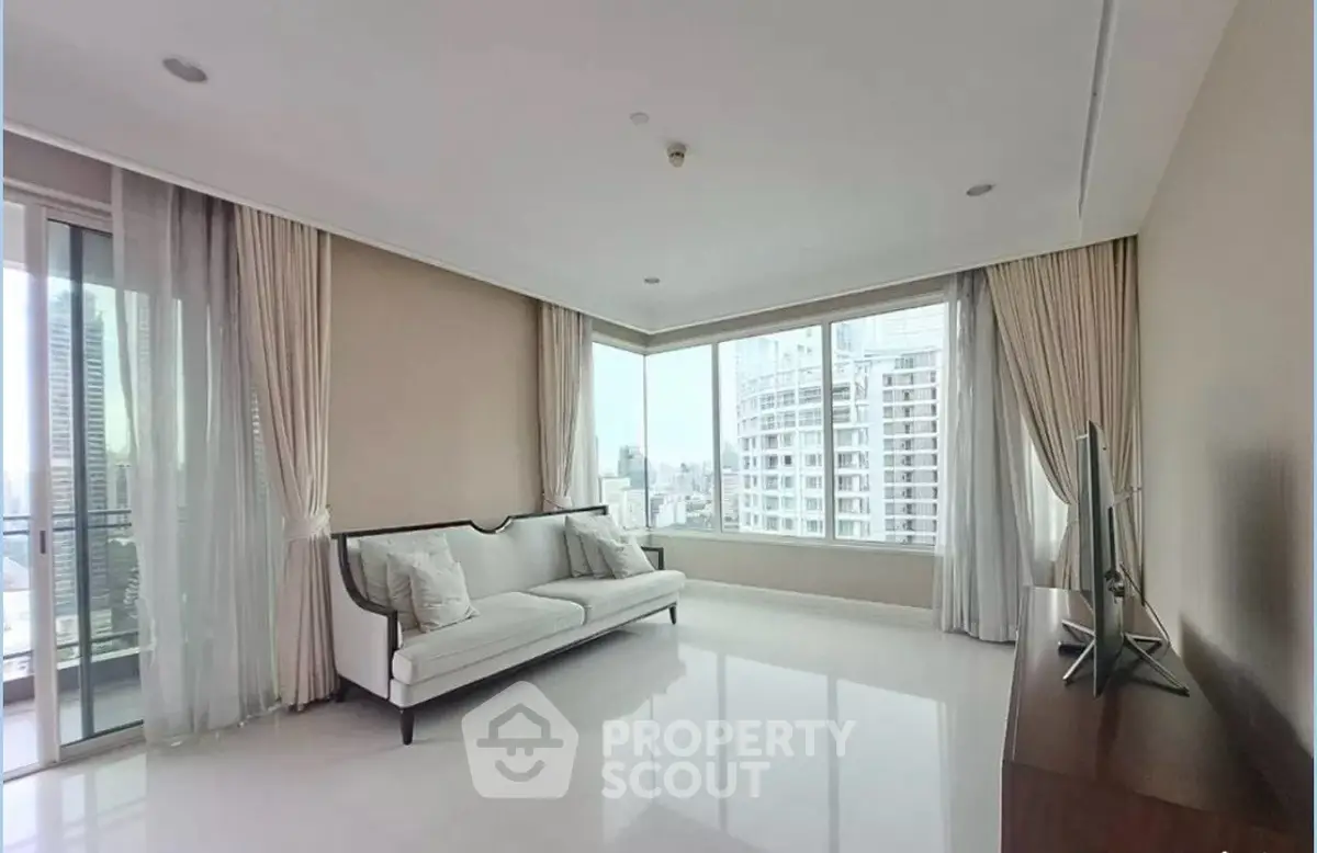 Spacious corner living room with large windows offering stunning city views, elegant sofa, and modern decor.