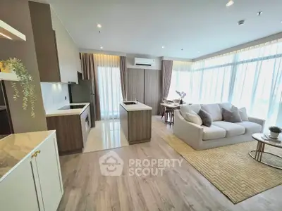 Spacious modern living room with open kitchen and large windows in a stylish apartment.