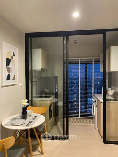 Modern kitchen with open layout and dining area, featuring sleek appliances and stylish decor.