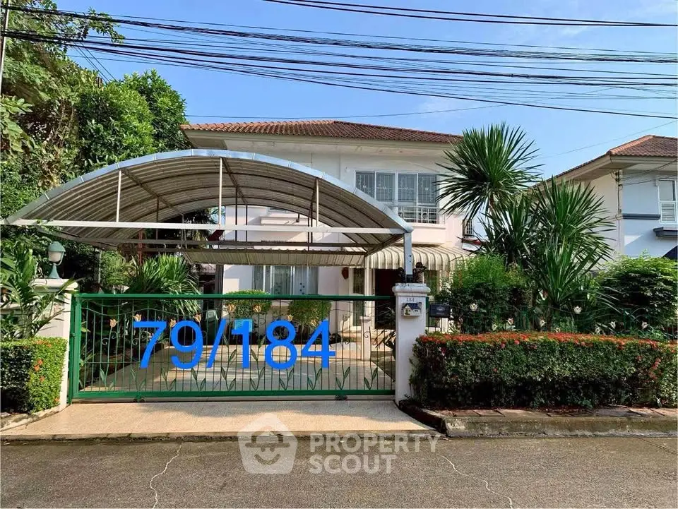 Charming suburban house with lush greenery and a covered carport, perfect for family living.