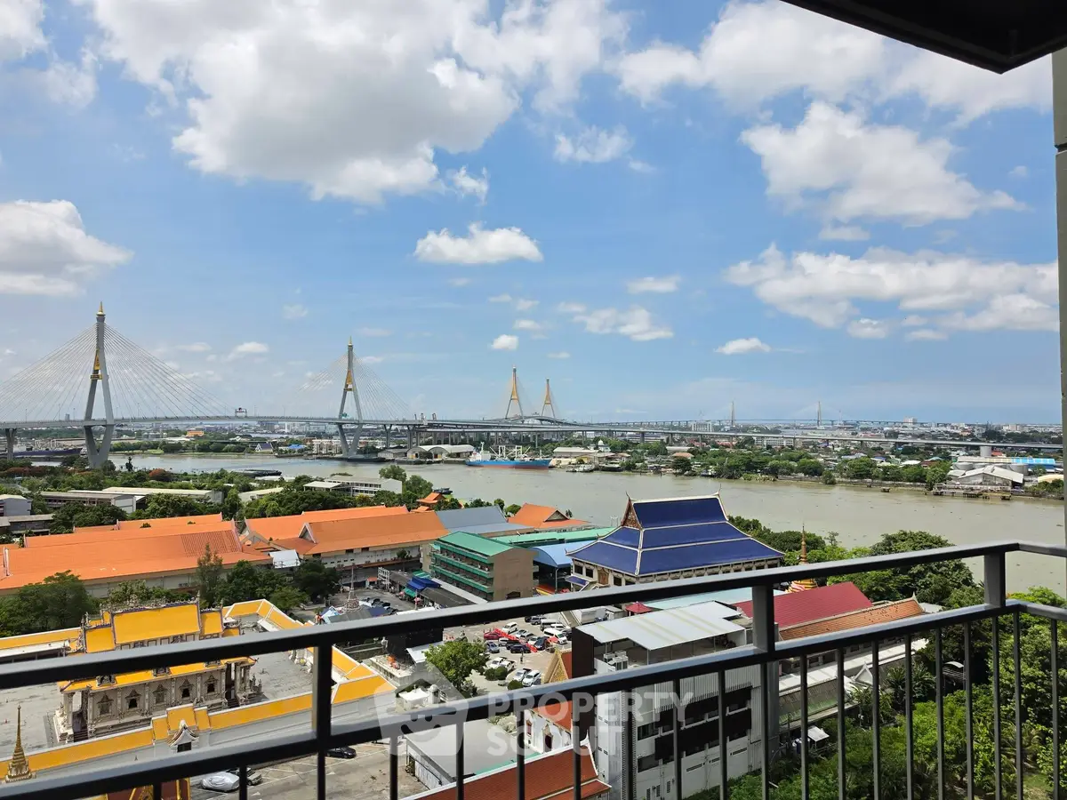 Stunning river view from high-rise balcony overlooking cityscape and iconic bridge.