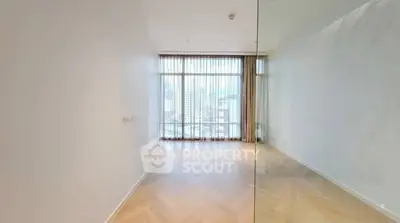 Spacious empty room with large window and city view, perfect for customization.
