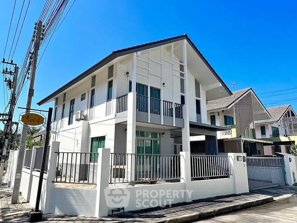 Modern two-story house with sleek design and spacious balcony in a suburban neighborhood.