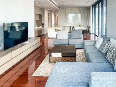 Spacious modern living room with sleek design and open kitchen layout, featuring large windows and elegant furnishings.