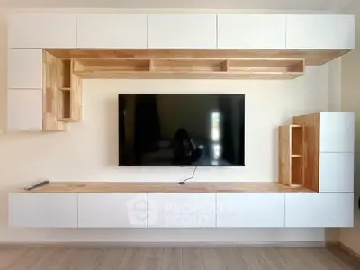 Modern living room with sleek wooden cabinetry and mounted TV for stylish home entertainment.