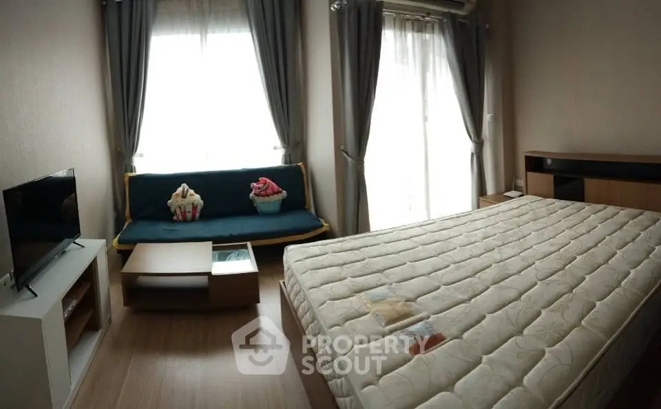Cozy bedroom with natural light, modern furnishings, and a comfortable mattress in a stylish apartment.