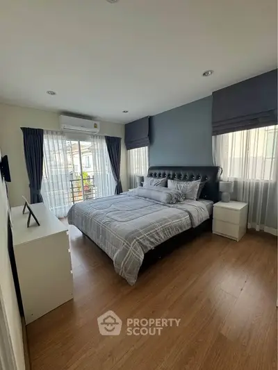 Spacious bedroom with modern decor and natural light, featuring a comfortable bed and stylish furnishings.