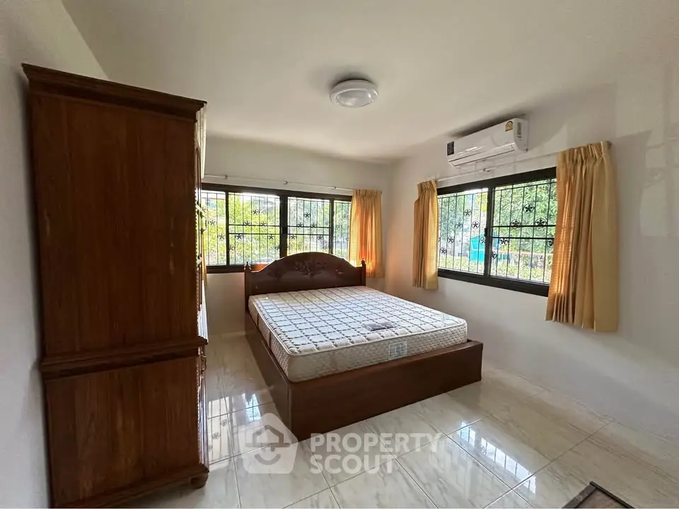 Spacious bedroom with large windows and air conditioning unit