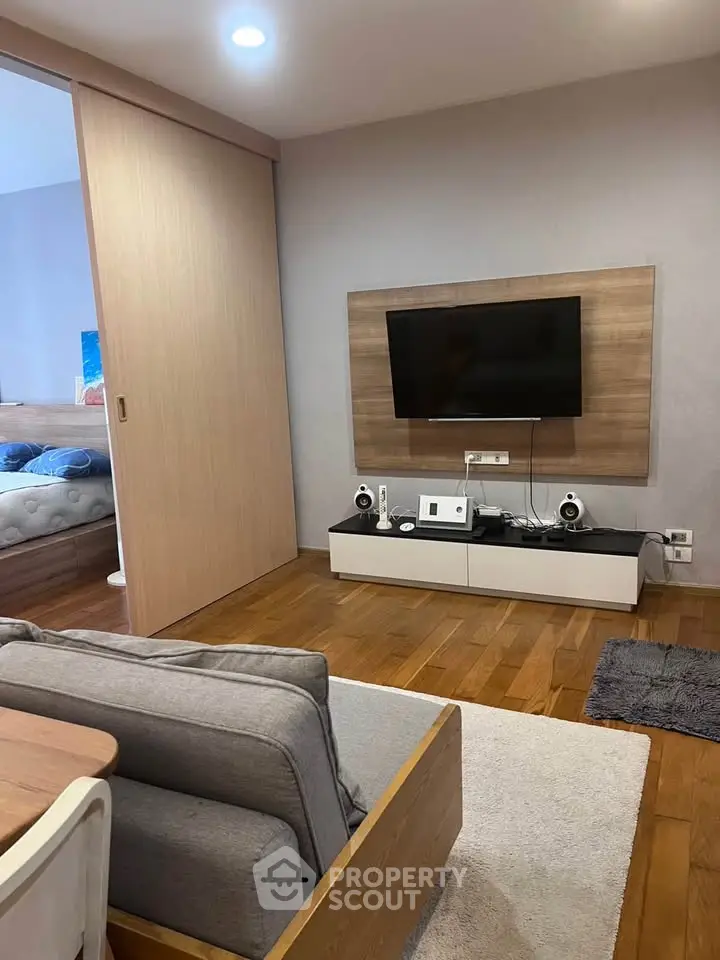Modern living room with wooden flooring and sleek entertainment setup