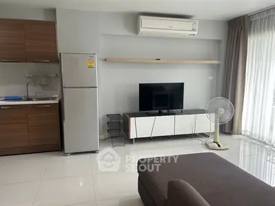 Modern living room with sleek kitchen, air conditioning, and natural light from large windows.