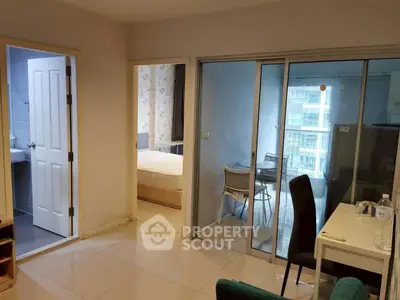 Modern apartment interior with open layout, featuring a bedroom, bathroom, and dining area with glass doors.