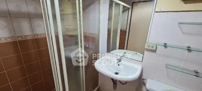 Compact bathroom with shower, sink, and toilet in a cozy real estate unit.