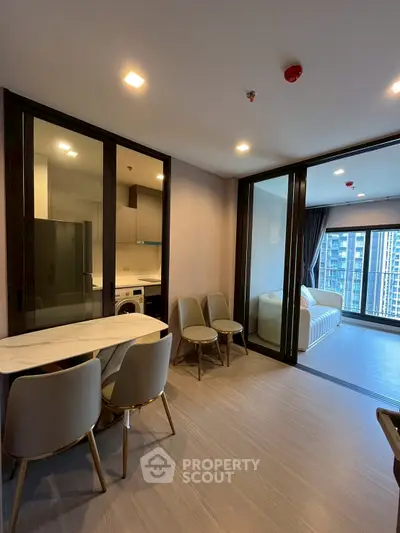 Modern apartment interior with open layout, featuring a stylish kitchen and spacious living area with city view.