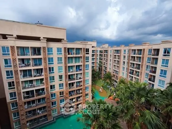 Stunning view of modern apartment complex with lush greenery and pool.
