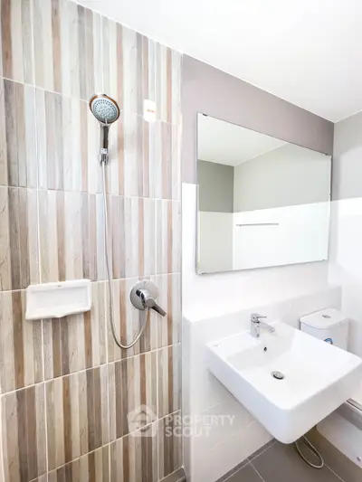 Modern bathroom with sleek sink and stylish shower in contemporary design.