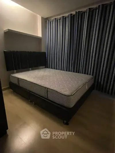 Cozy bedroom with modern bed and striped curtains, perfect for restful nights.