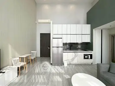 Modern open-layout kitchen with sleek appliances and stylish dining area in a contemporary apartment.