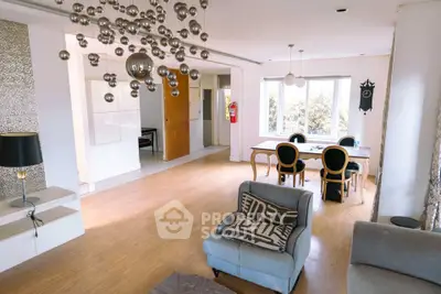 Spacious living room with modern decor and unique lighting fixtures.