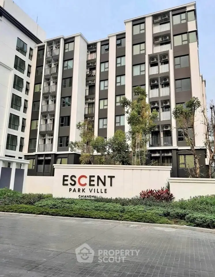 Modern condominium building exterior at Escent Park Ville Chiangmai with lush greenery and sleek design.