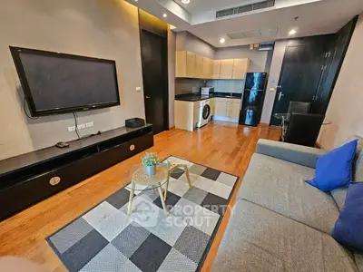 Modern living room with open kitchen, featuring sleek appliances and stylish decor.