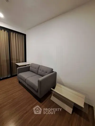 Modern living room with sleek gray sofa and wooden flooring, perfect for cozy urban living.
