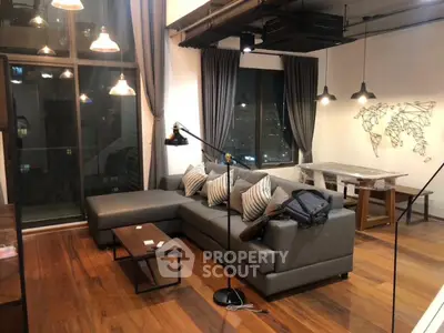Modern living room with stylish decor and city view, featuring a cozy sectional sofa and elegant lighting.