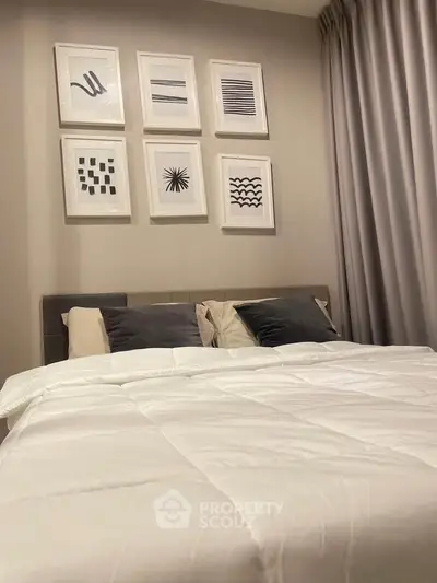 Cozy bedroom with modern art decor and plush bedding, perfect for relaxation.