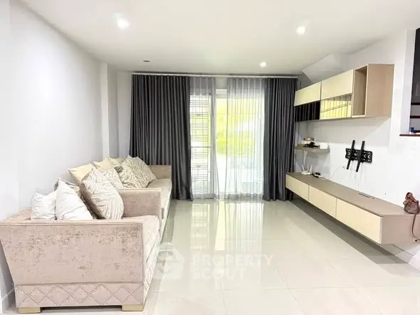 Spacious modern living room with elegant sofa and large windows