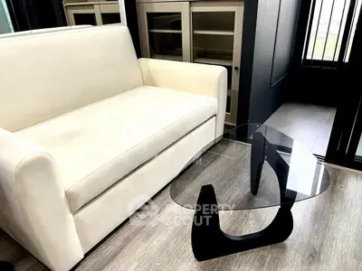 Modern living room with sleek glass coffee table and cream sofa, perfect for stylish urban living.