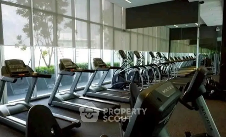 Modern gym with multiple treadmills and large windows in a luxury apartment building.
