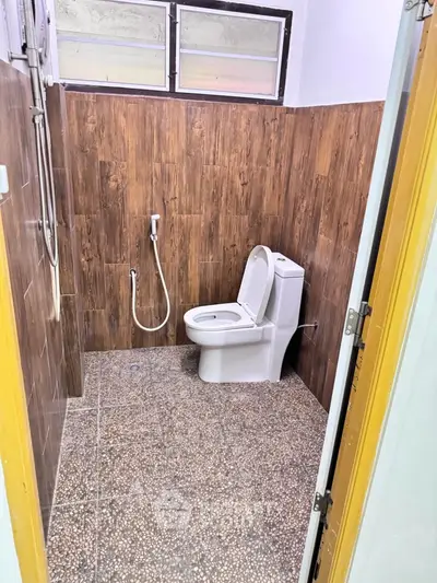 Modern bathroom with wooden wall tiles and sleek toilet design
