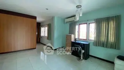 Spacious room with large windows and air conditioning, ideal for versatile living space.