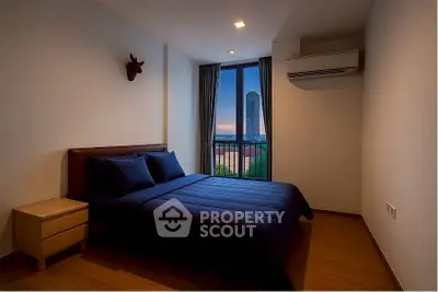 Cozy bedroom with city view, featuring modern decor and air conditioning.