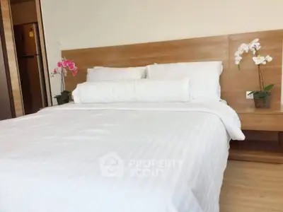 Luxurious bedroom with elegant wooden headboard and fresh white linens, perfect for relaxation and comfort.