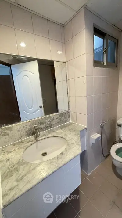 Spacious bathroom with marble countertop and modern fixtures in a stylish real estate property.