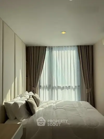 Cozy bedroom with elegant curtains and soft lighting, perfect for relaxation.