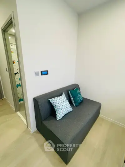 Modern interior with sleek gray sofa and decorative pillows in a cozy corner.