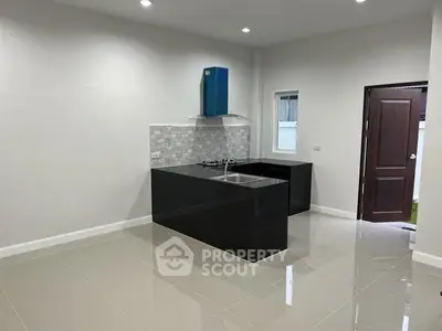 Modern kitchen with sleek black countertops and gas stove in a bright, open space.