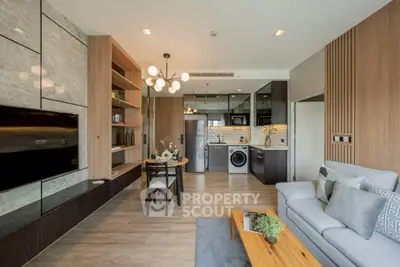 Modern living room with open kitchen, stylish decor, and built-in appliances in a contemporary apartment.